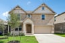 home with brick, windows, a tree and landscaped grass