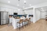 kitchen with brown flooring, quartz countertops and pendant lighting