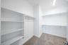 primary bedroom closet with carpet and white shelves