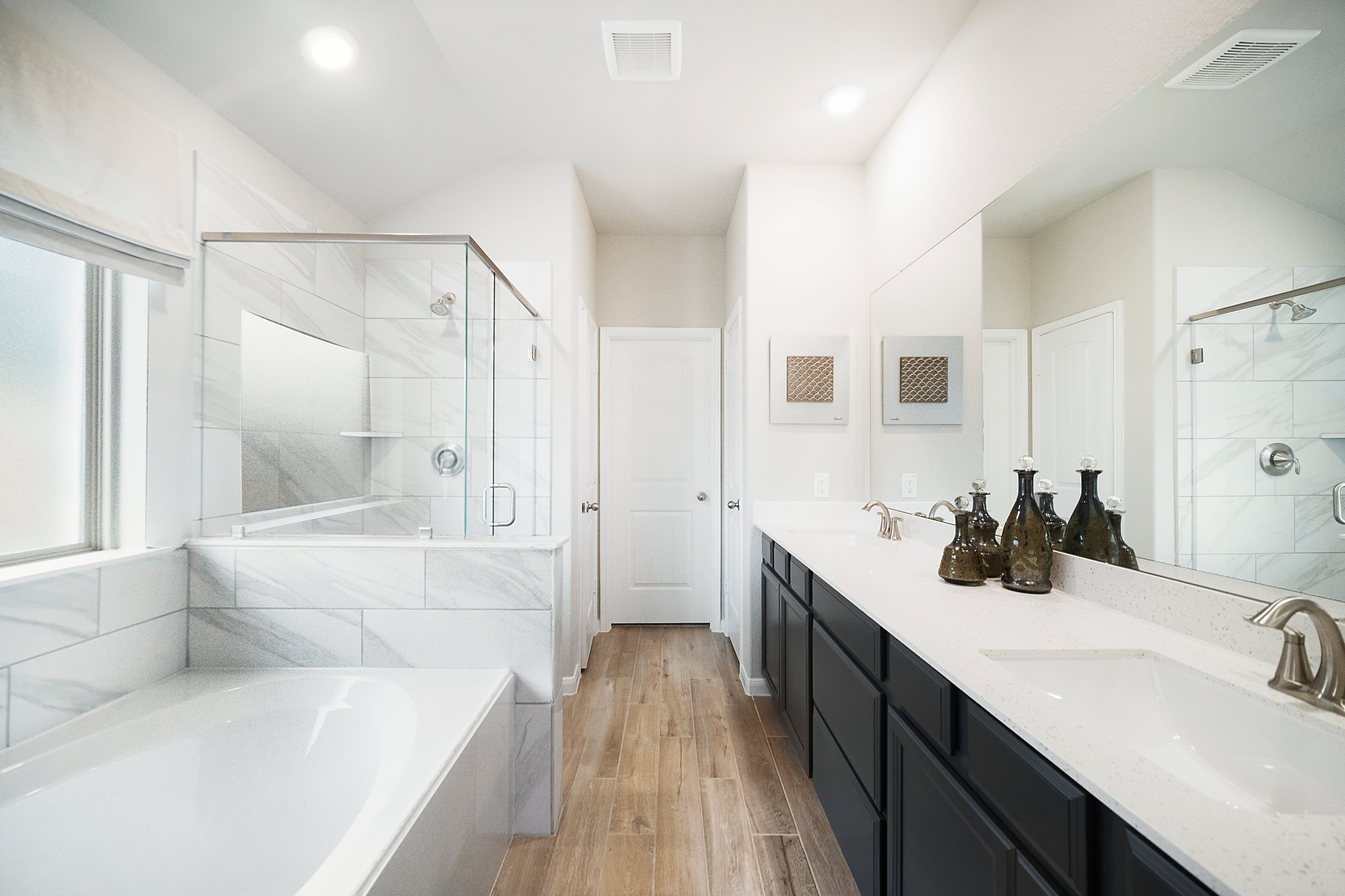 primary bathroom with double sinks and white tub